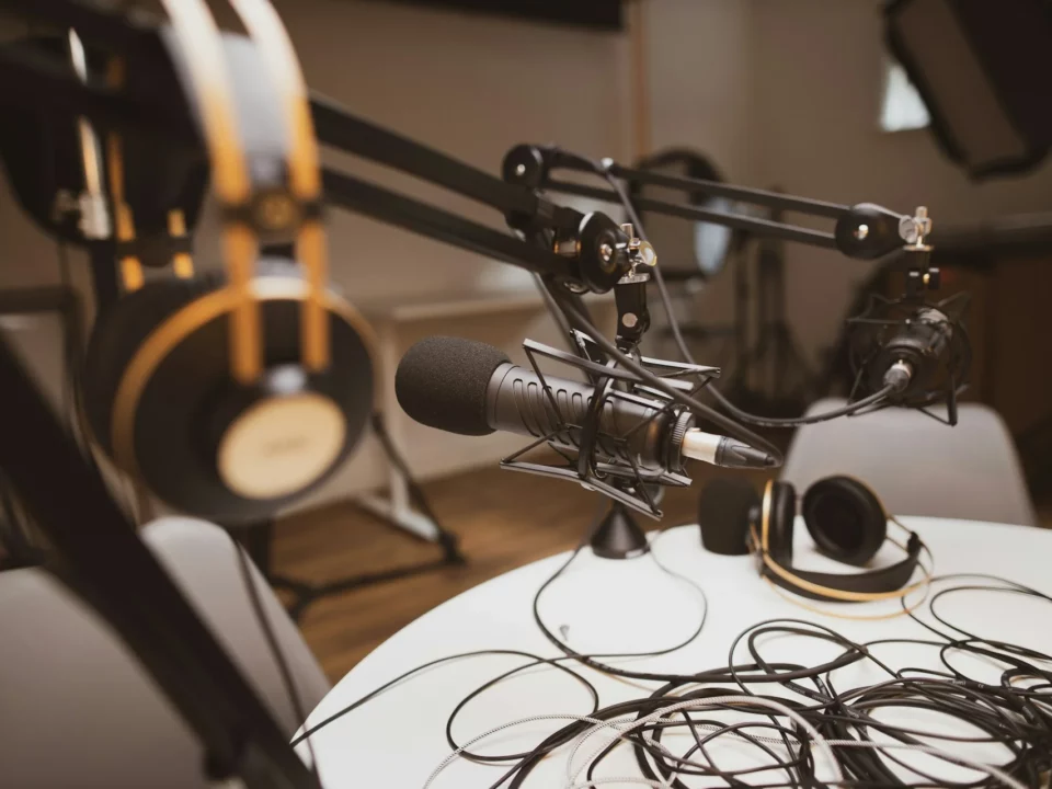 Plusieurs microphones autour d'une table sont en train d'être brnachés pour la préparation d'un podcast