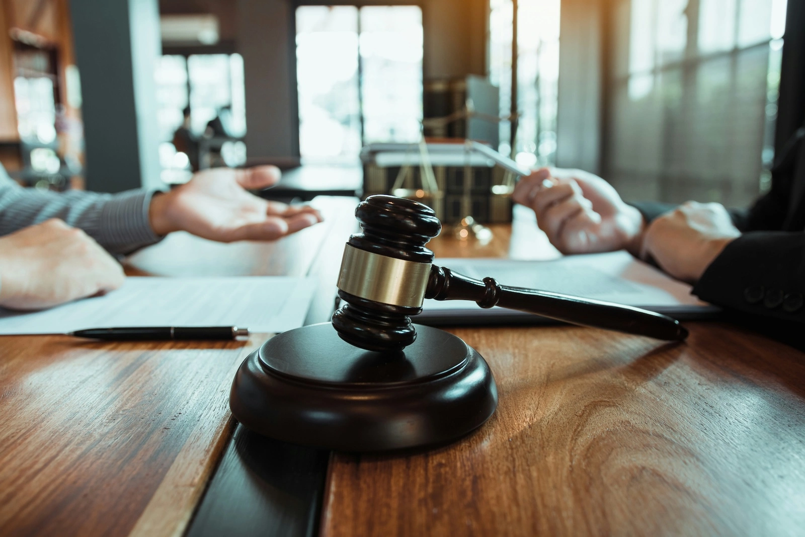Veille réglementaire : marteau de la justice avec des personnes en réunion