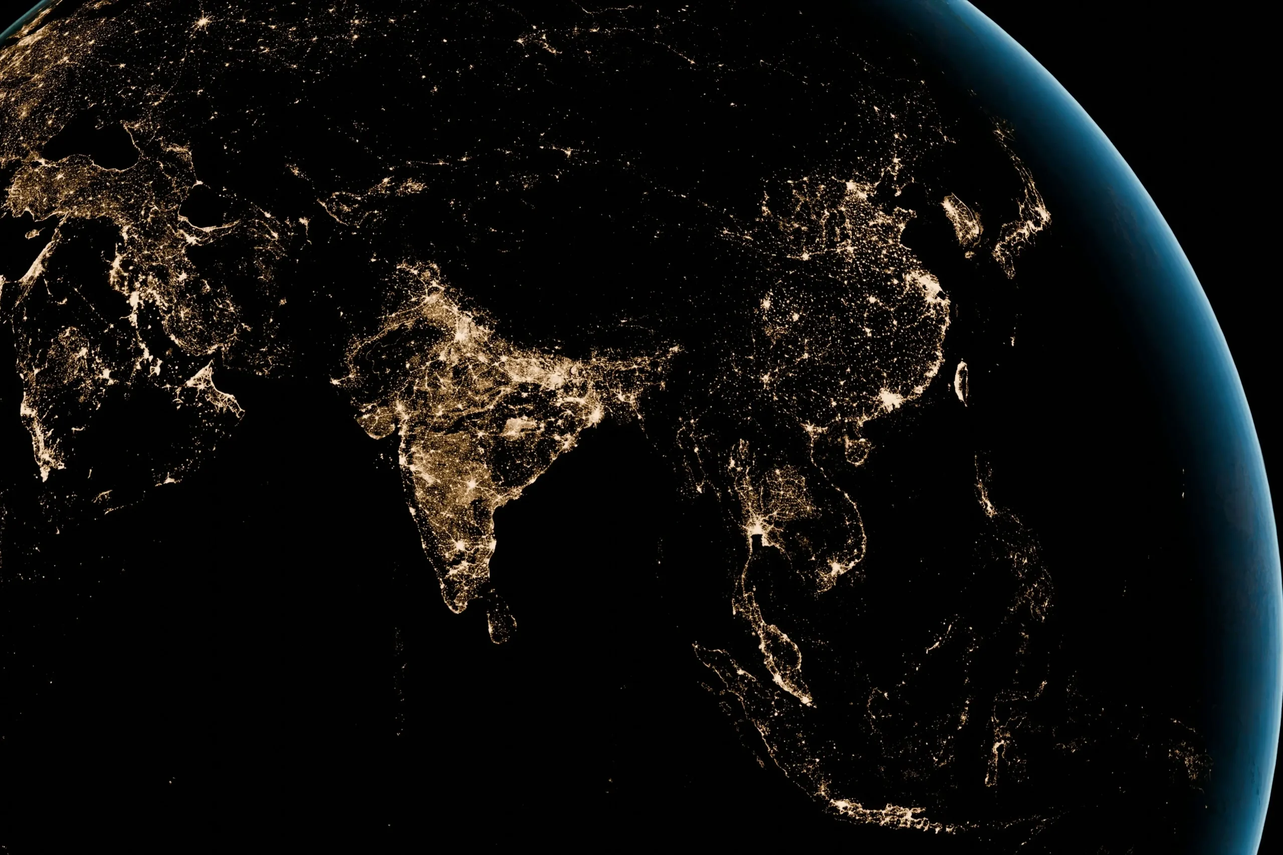 Vue de la Terre depuis l'espace de nuit, révélant les lumières des grandes métropoles d'Asie et du Moyen-Orient, symbole des interconnexions géopolitiques mondiales