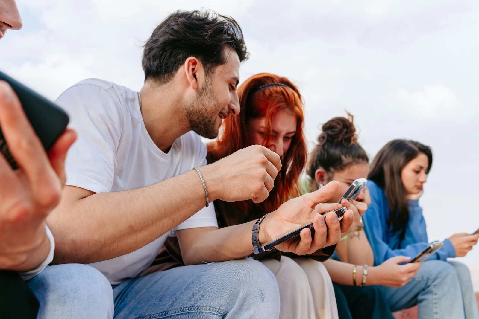 Veille réseaux sociaux : personnes qui discutent avec leur téléphone en main